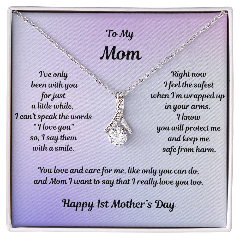 White Gold Alluring Beauty Necklace Drop Pendant Style with a Large CZ crystal in center and small crystals accenting. Message reads: To My Mom: I've only been with you for just a little while, I can't speak the words "I love you" so I say them with a smile. Right now I feel the safest when I'm wrapped up in your arms. I know you will protect me and keep m safe from harm. You love and care for me, like only you can do, and Mom I want to say that I really love you too. Happy 1st Mother's Day.
