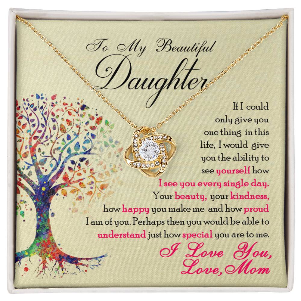 Yellow Gold Love Knot Necklace with a large CZ crystal at the center surrounded by smaller crystals. Shown in a Standard Gift Box. Message card reads :To My Beautiful Daughter: If I could only give you one thing in this life, I would give you the ability to see yourself how I see you every single day. Your beauty, your kindness, how happy you make me and how proud I am of you. Perhaps then you would be able to understand just how special you are to me. I love you, Love, Mom. With a colorful image of a tree.