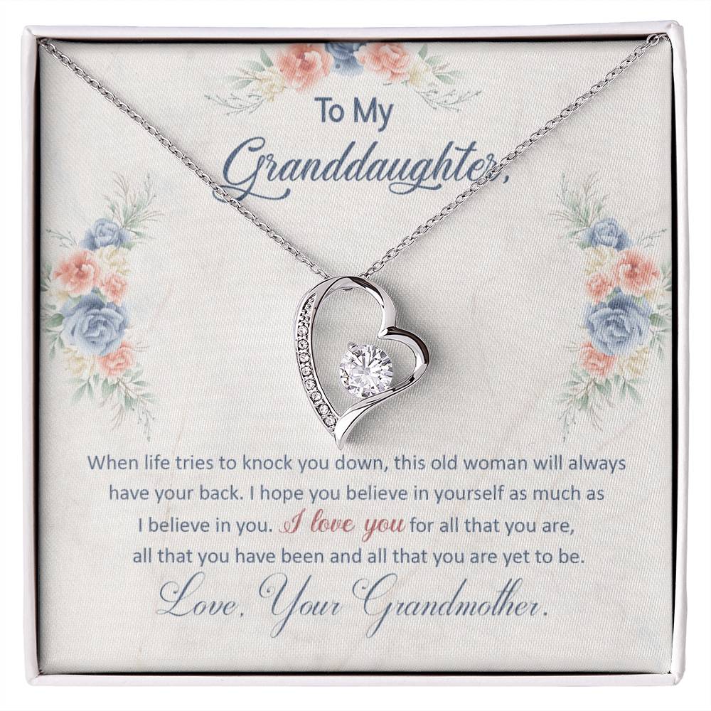 White Gold Forever Love Heart Necklace with large CZ crystal in center, and smaller crystals along one side. Shown in Standard Gift Box. Message reads:To My Granddaughter: When life tries to knock you down, this old woman will always have your back. I hope you believe in yourself as much as I believe in you. I love you for all that you are, all that you have been, and all that you are yet to be. Love, Your Grandmother.