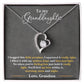 White Gold Forever Love Heart Necklace with large CZ crystal at the center and maller crystals on one side. Shown in Standard Gift Box. Message reads: To My Granddaughter: I hugged this little pendant, I squeezed it really tight. I filled it with my wishes, hope and love and light. So when you're feeling low just hold it really tight. You'll feel my love within it morning, noon, and night. Love, Grandma
