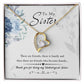 Yellow Gold Forever Love Heart Necklace. Large CZ crystal at center with small crystals along one side. Shown in Standard Gift Box. Message reads:To My Sister: There are friends, there is family, and then there are friends who become family... thank you for being my unbiological sister. There are blue flowers in the background.